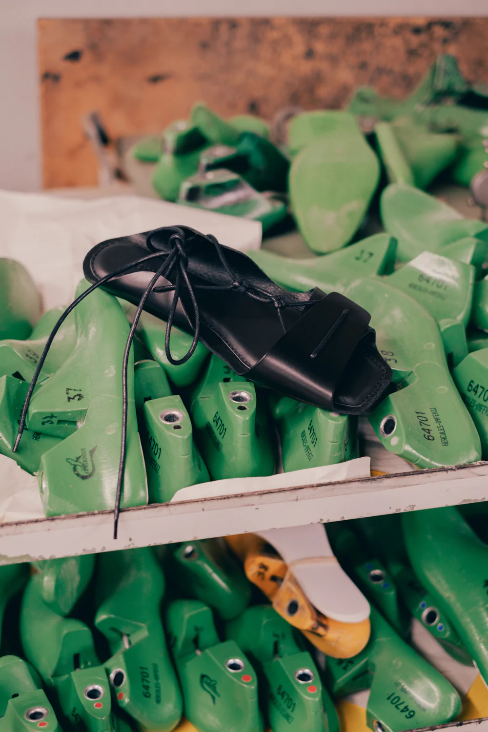 A bunch of green shoes on a shelf.