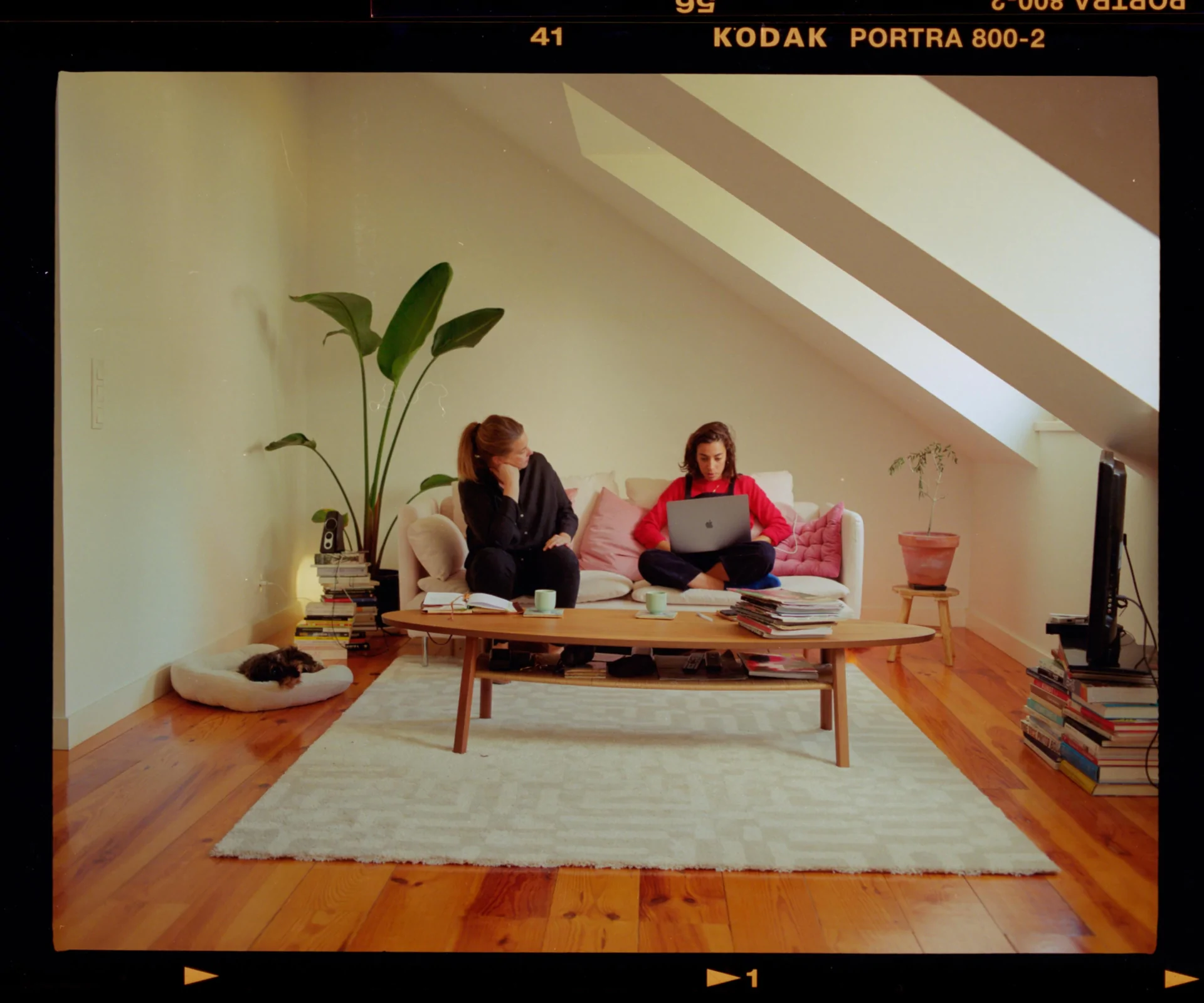 Two women sitting on a couch in a living room.