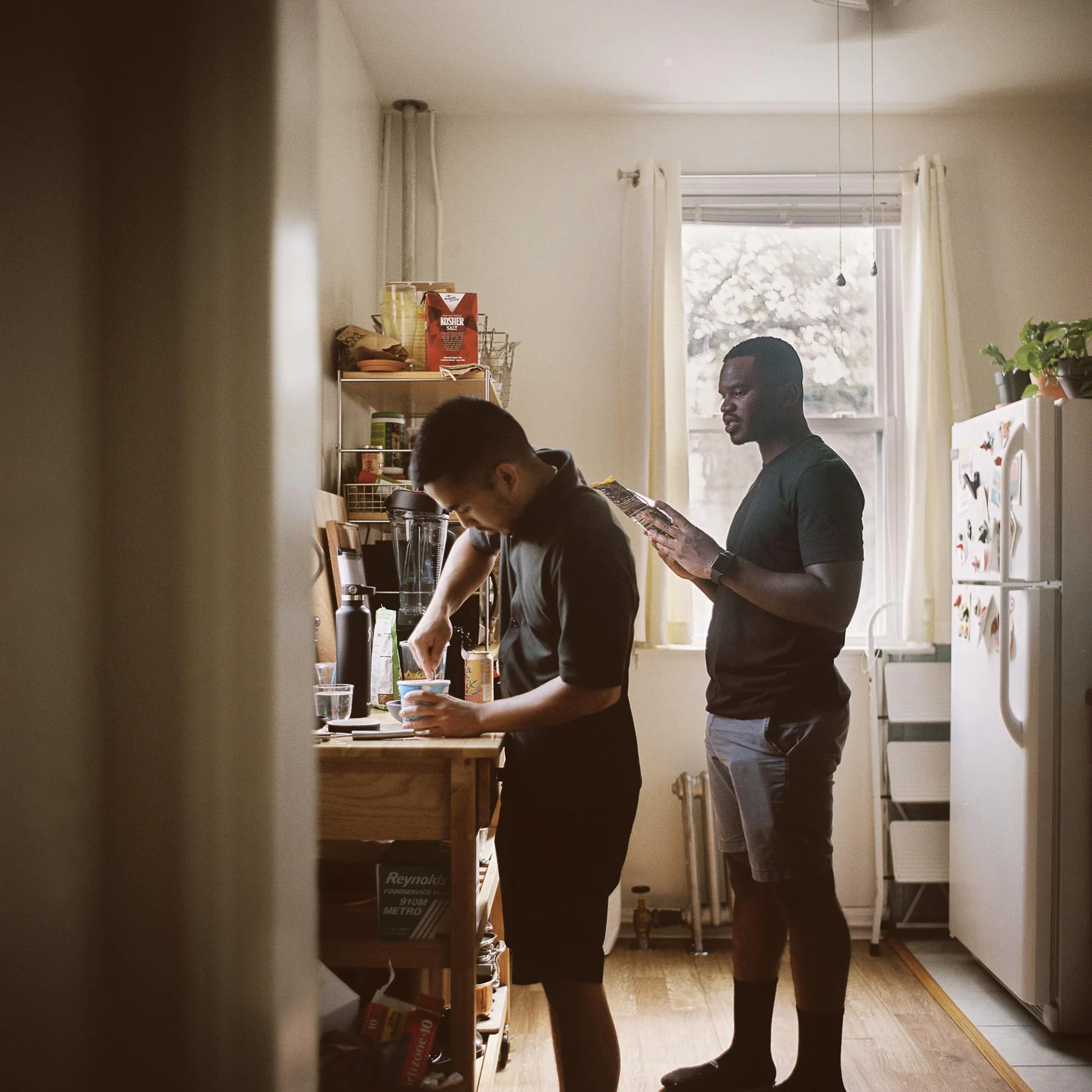 A man and a boy standing in a kitchen.