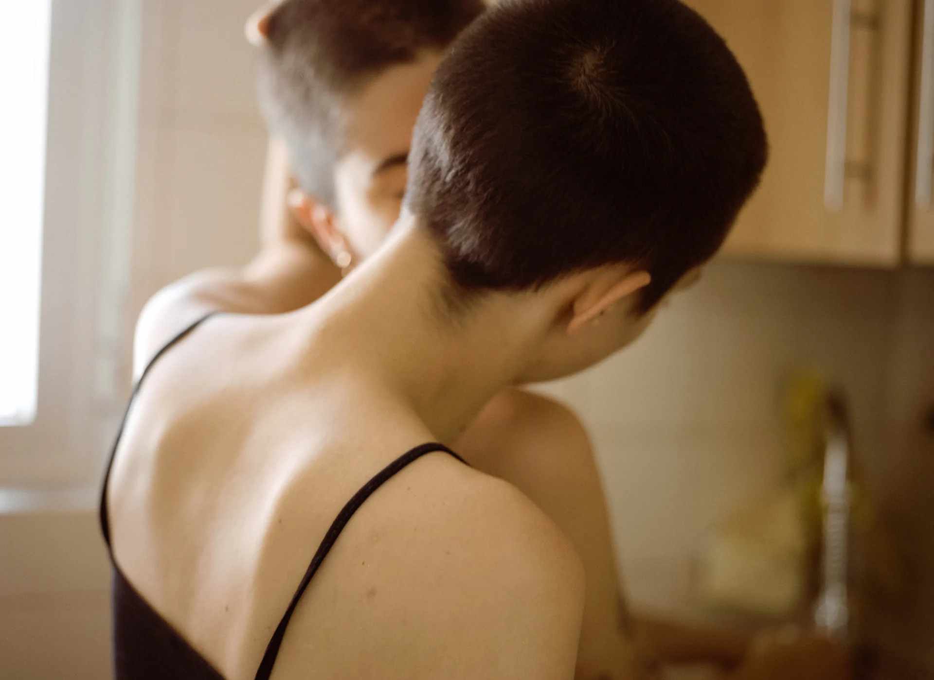 A woman is putting her hair up in a mirror.