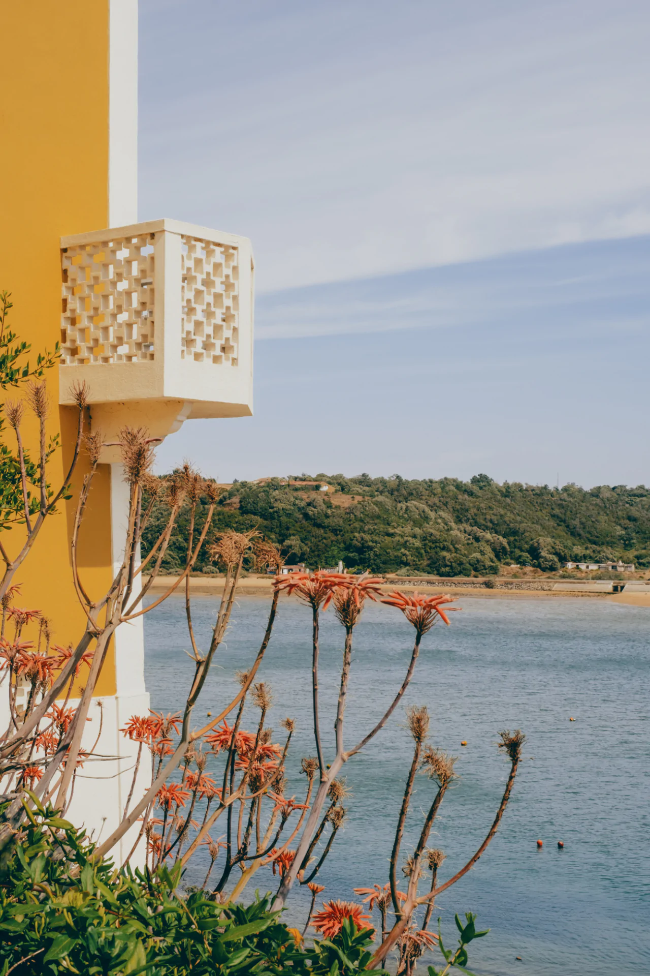 A yellow building with a balcony overlooking the ocean.