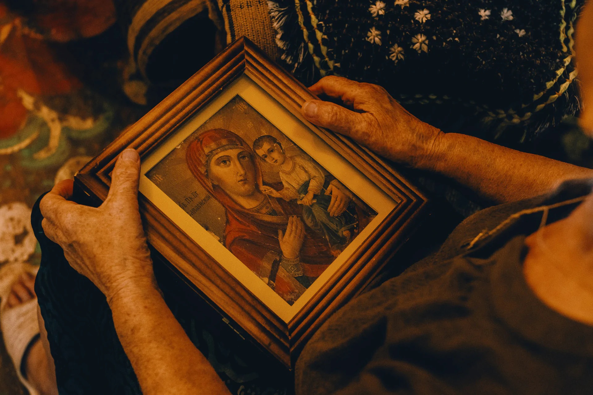A woman holding up a framed picture.