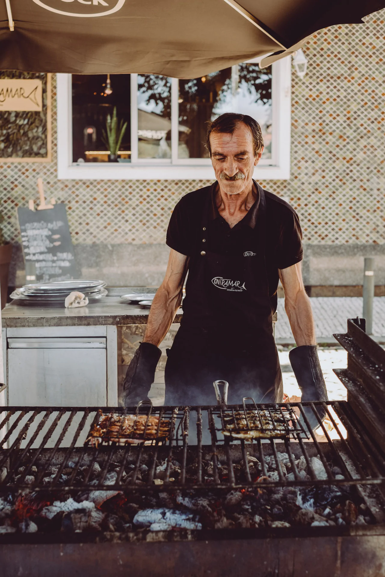 A man is preparing food on a grill.