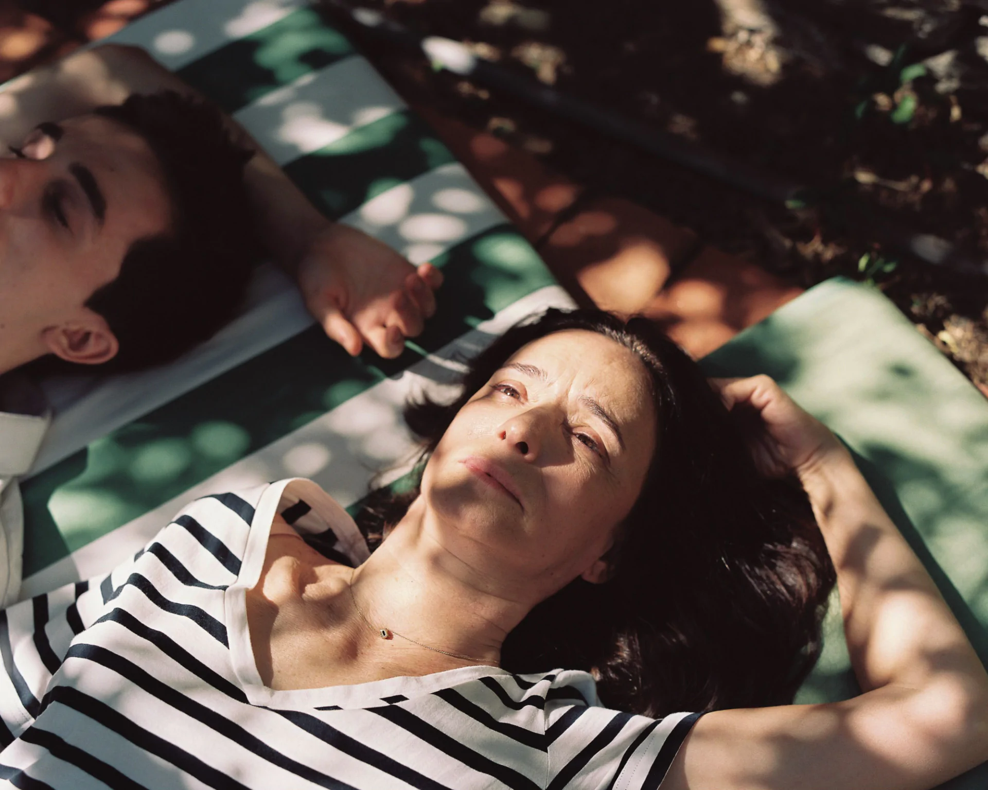 A man and a woman laying on a blanket.