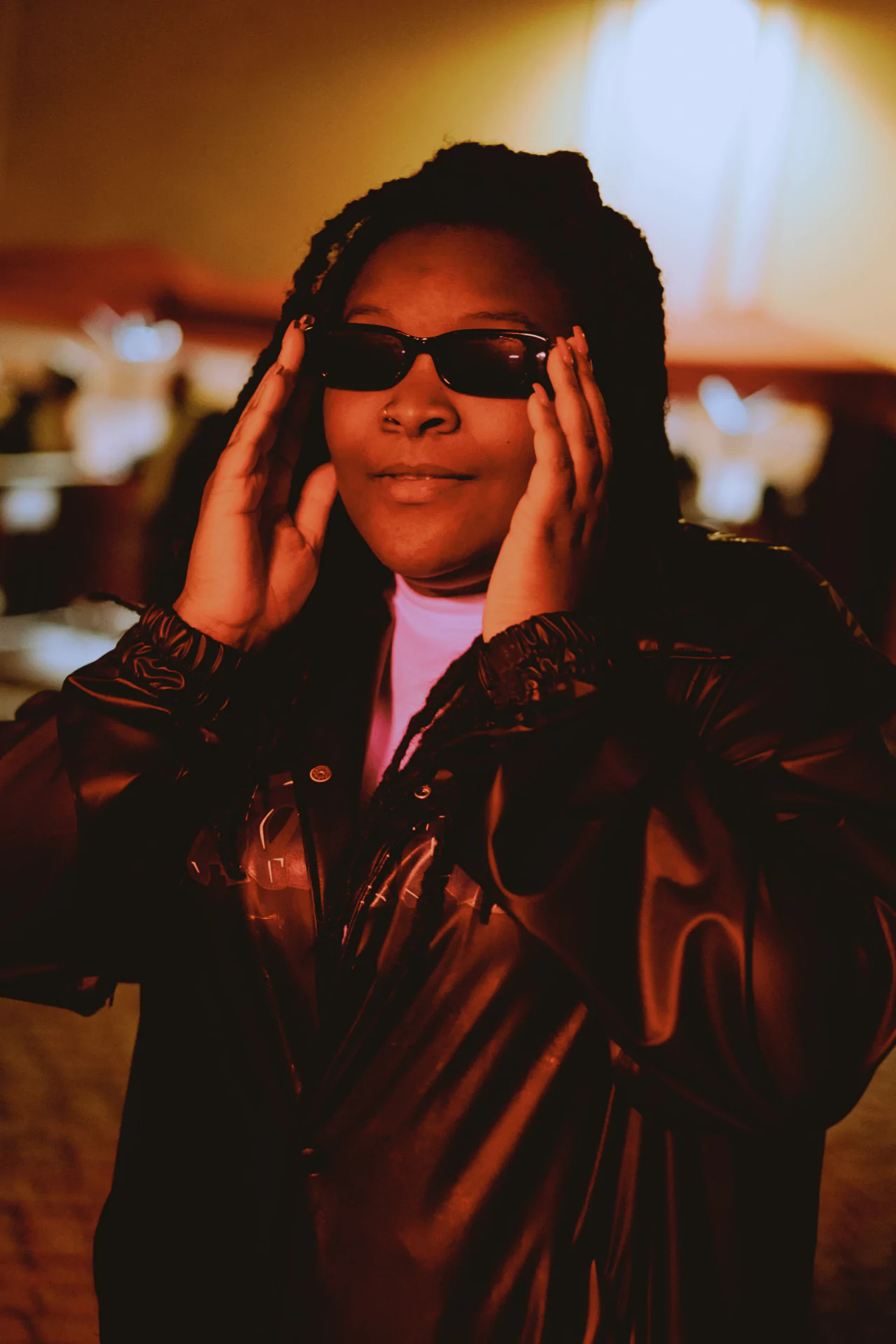 A woman wearing sunglasses and a leather jacket.