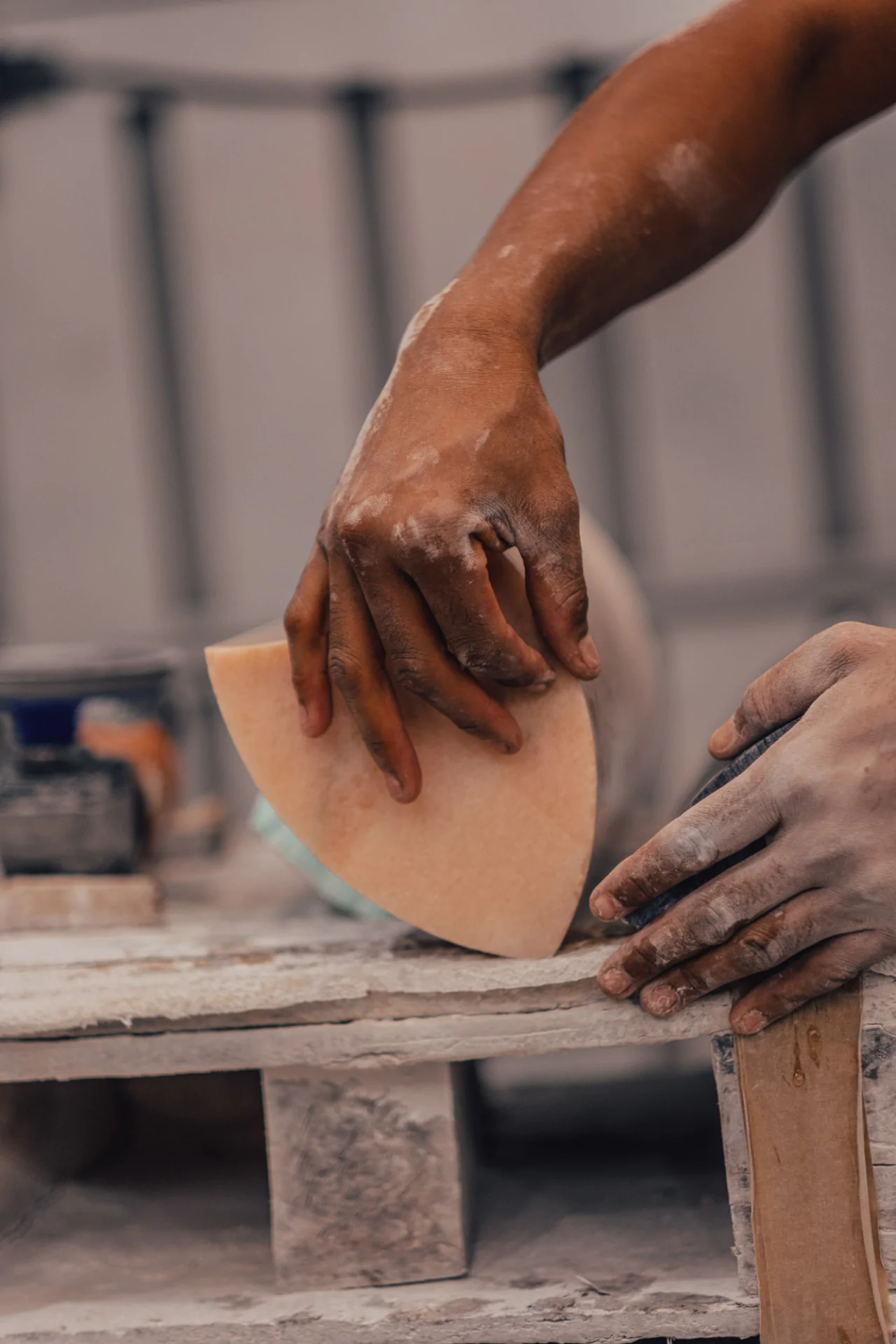 Craftsman's hands delicately touching marble surface during creation of Cartier Trinity Ring anniversary table