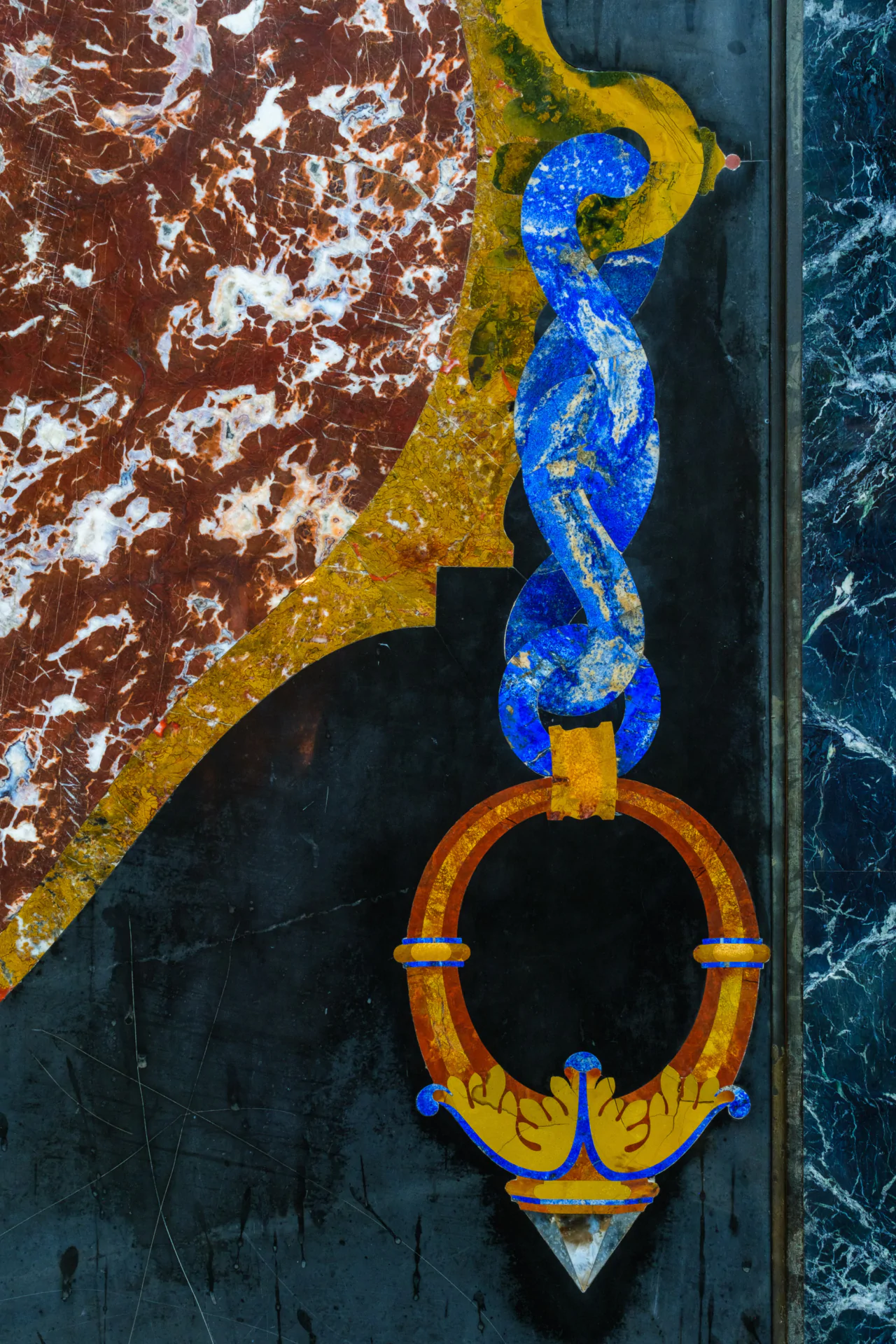 Decorative wall panel with ornate design features a large blue chain and orange ring against a marbled background, incorporating rich textures and colors.