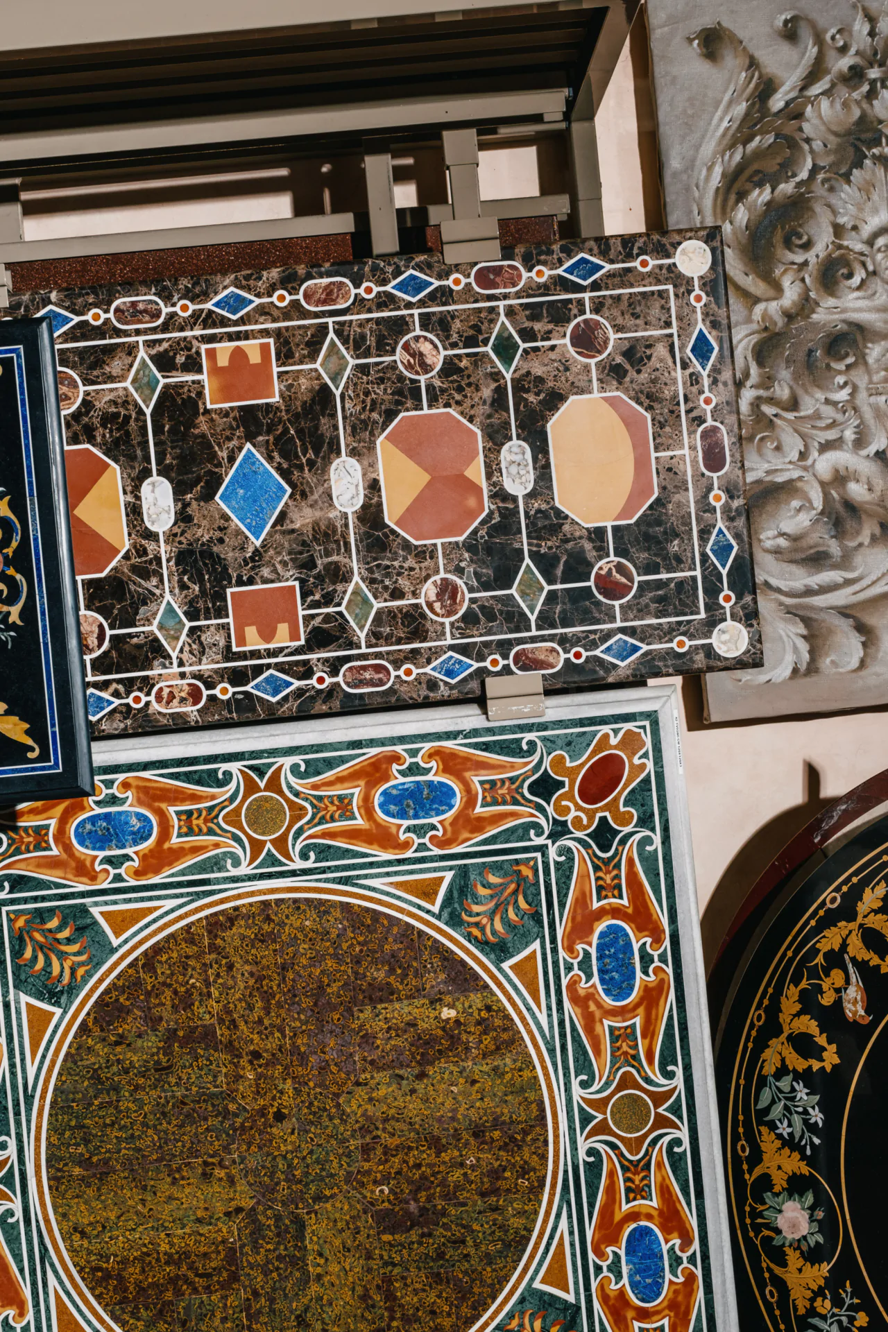 Decorative mosaic tiles with intricate geometric and floral patterns in various colors, displayed flat on a surface.