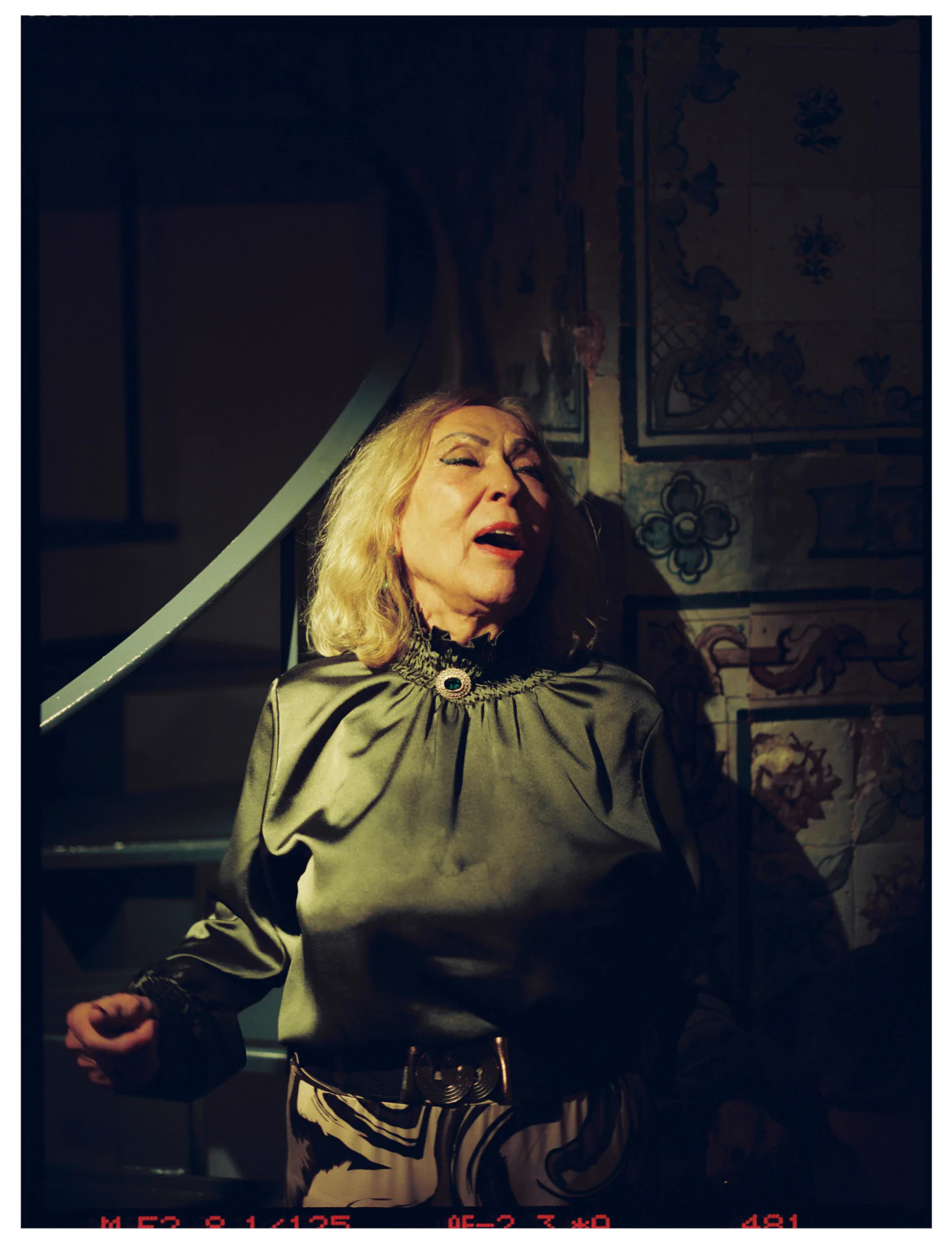 Fado singer performing in dramatic lighting traditional Lisbon venue